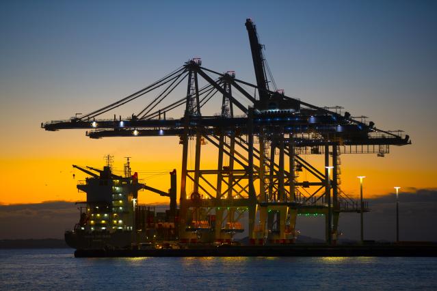 Container cranes loading a ship at sunset at Port of Auckland